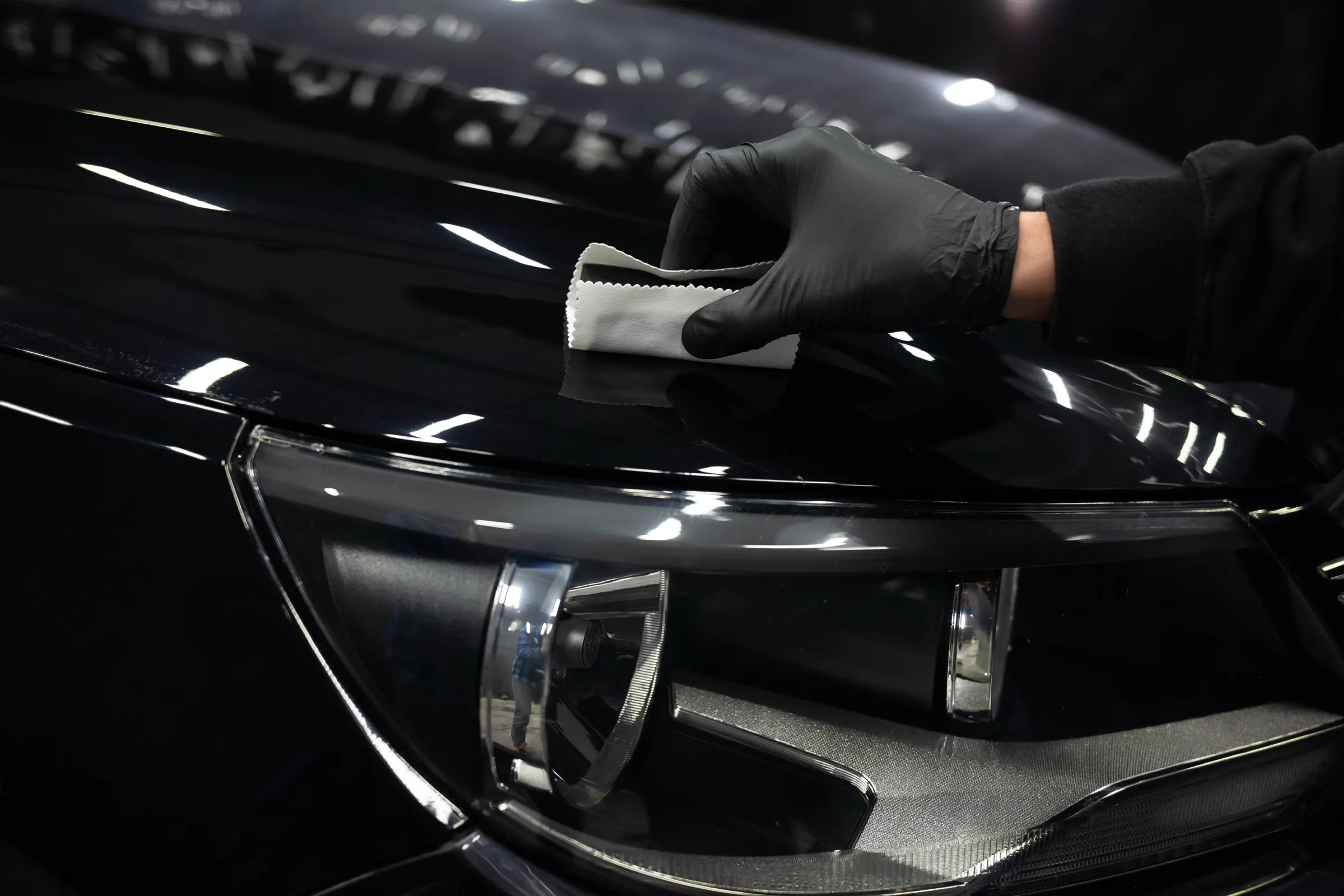 Ceramic coating being applied to dark vehicle paint